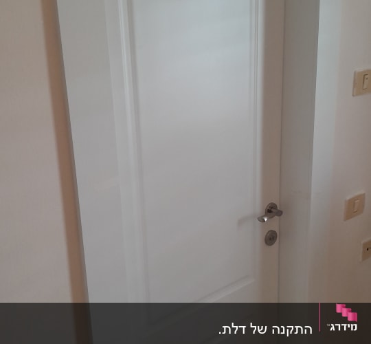 דלת לבנה עם ידית מתכת כסופה